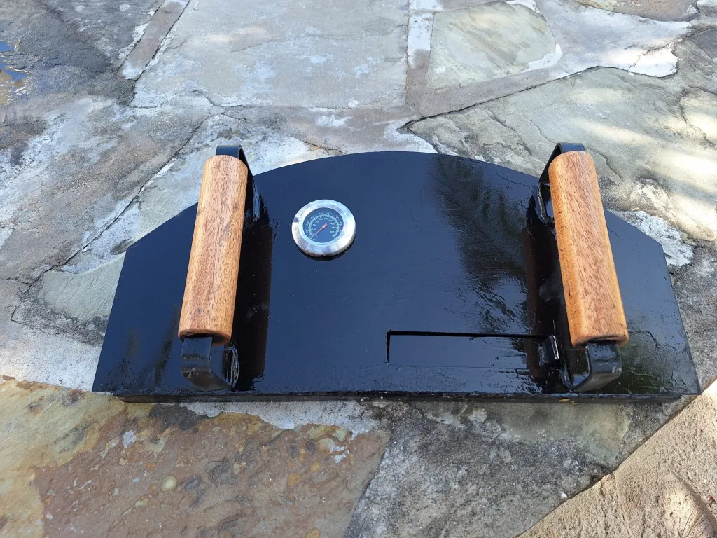 Wood-fired oven door with thermometer and timber handles